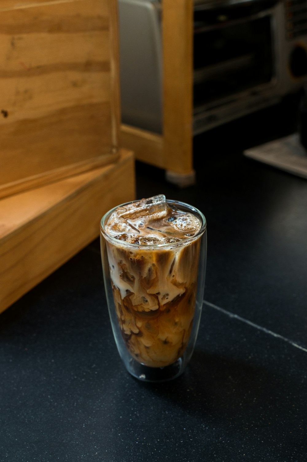 a glass of iced coffee sitting on a counter