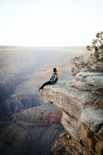 a person sitting on top of a cliff