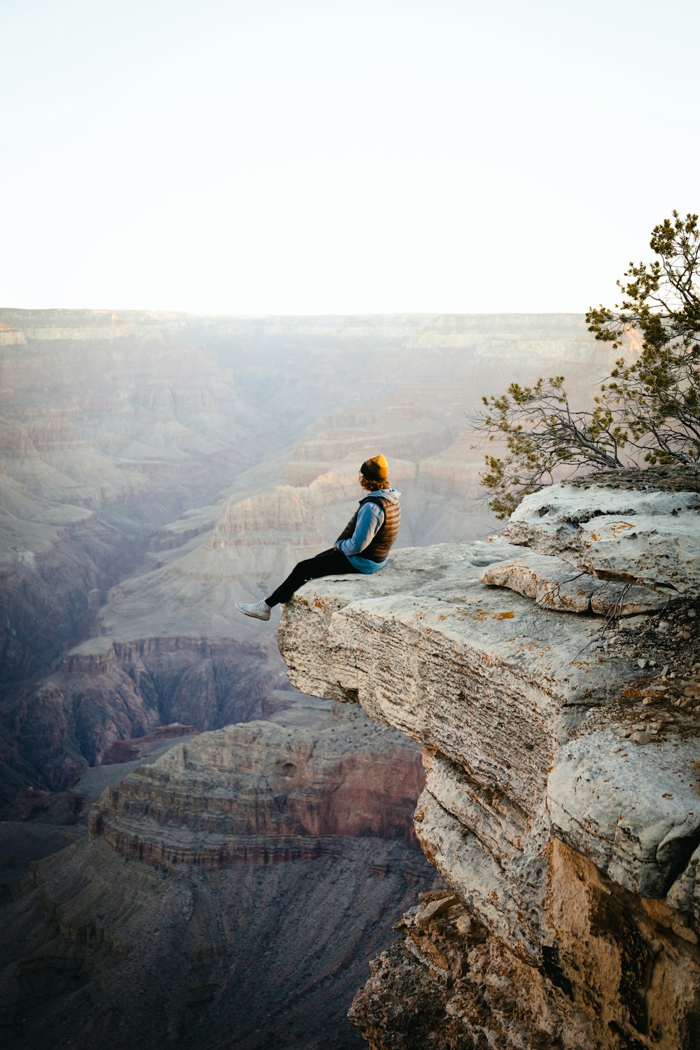 une personne assise au sommet d’une falaise