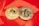 Two gold coins are placed on a glossy red surface, featuring the symbols for Bitcoin and Tezos. The coins are intricately designed with digital circuit patterns, symbolizing their status as cryptocurrencies.