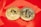 Two gold coins are placed on a glossy red surface, featuring the symbols for Bitcoin and Tezos. The coins are intricately designed with digital circuit patterns, symbolizing their status as cryptocurrencies.