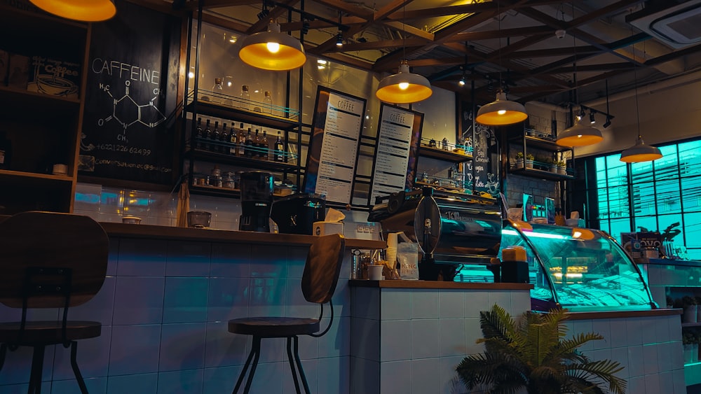 a restaurant with a counter and several lights hanging from the ceiling