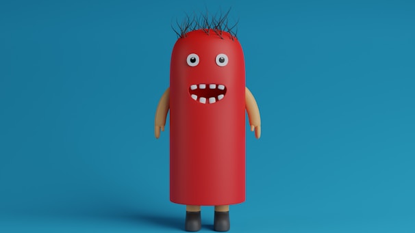 A whimsical, cartoonish character with a cylindrical, red body resembling a hot dog stands against a blue background. It has googly eyes, a wide open mouth with a few white teeth, spiky black hair, and tan-colored arms and brown shoes.
