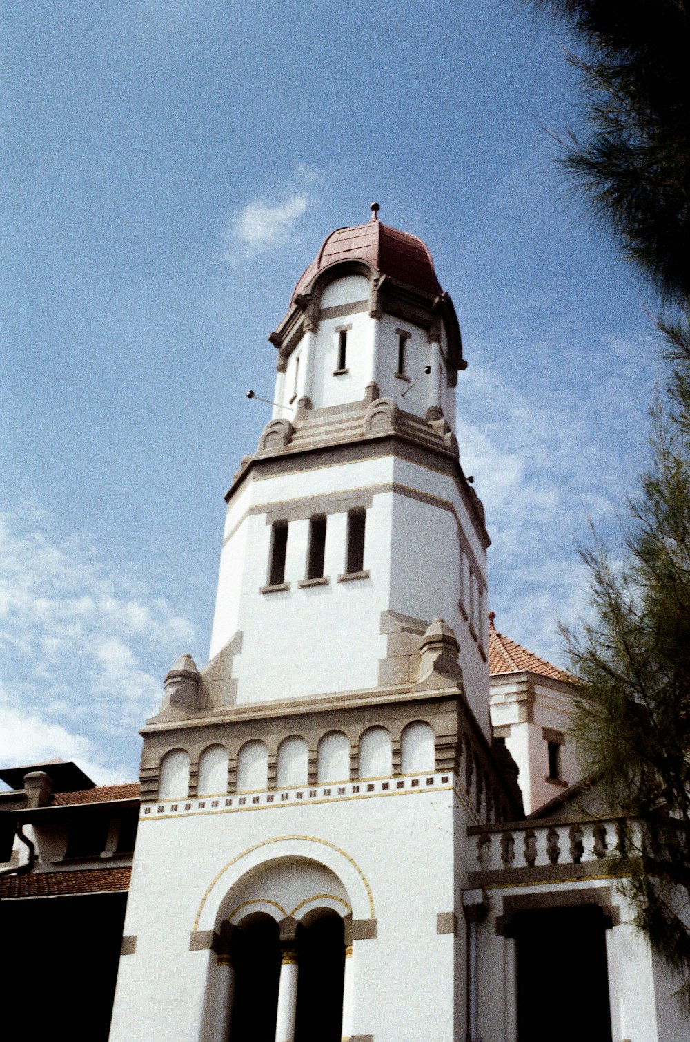 a tall white building with a red roof