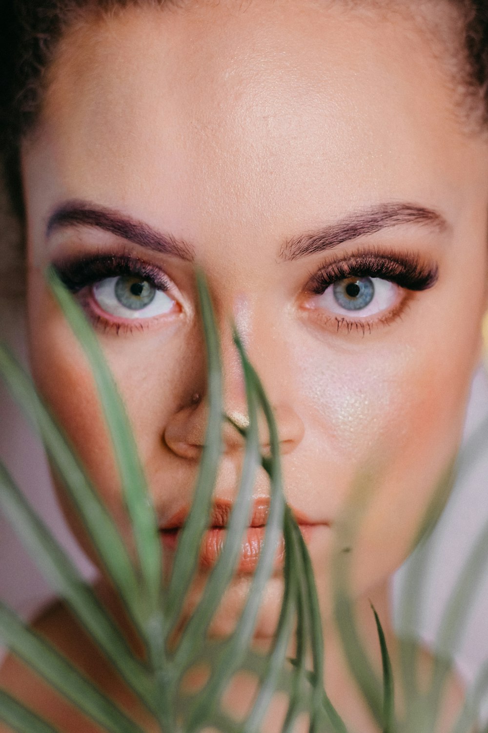 a woman with blue eyes is holding a plant