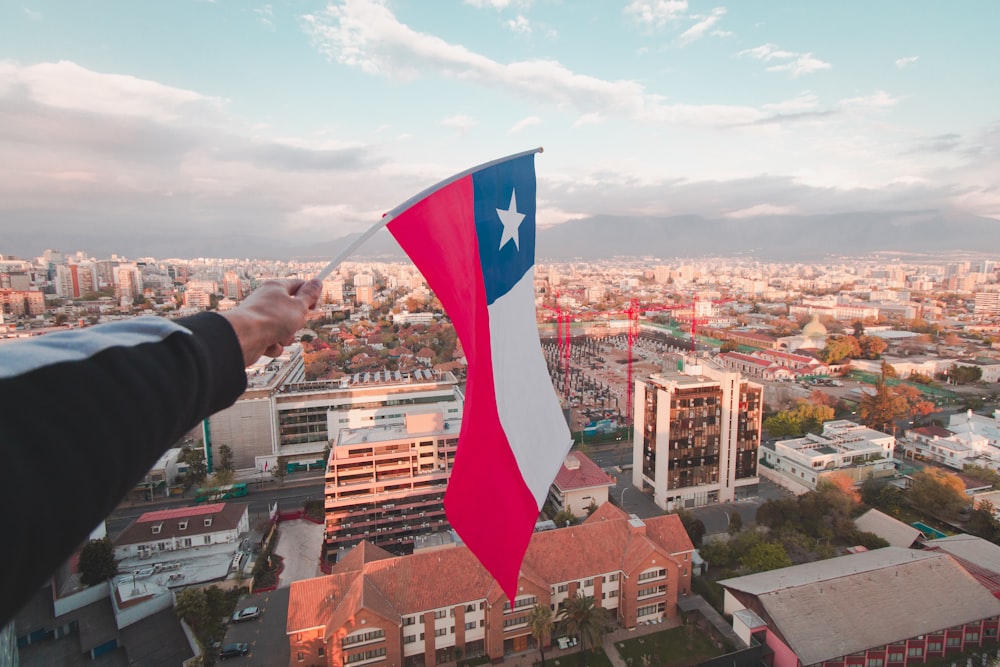 Una persona che tiene una bandiera del Texas su una città