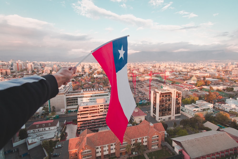 a person holding a texas flag over a city