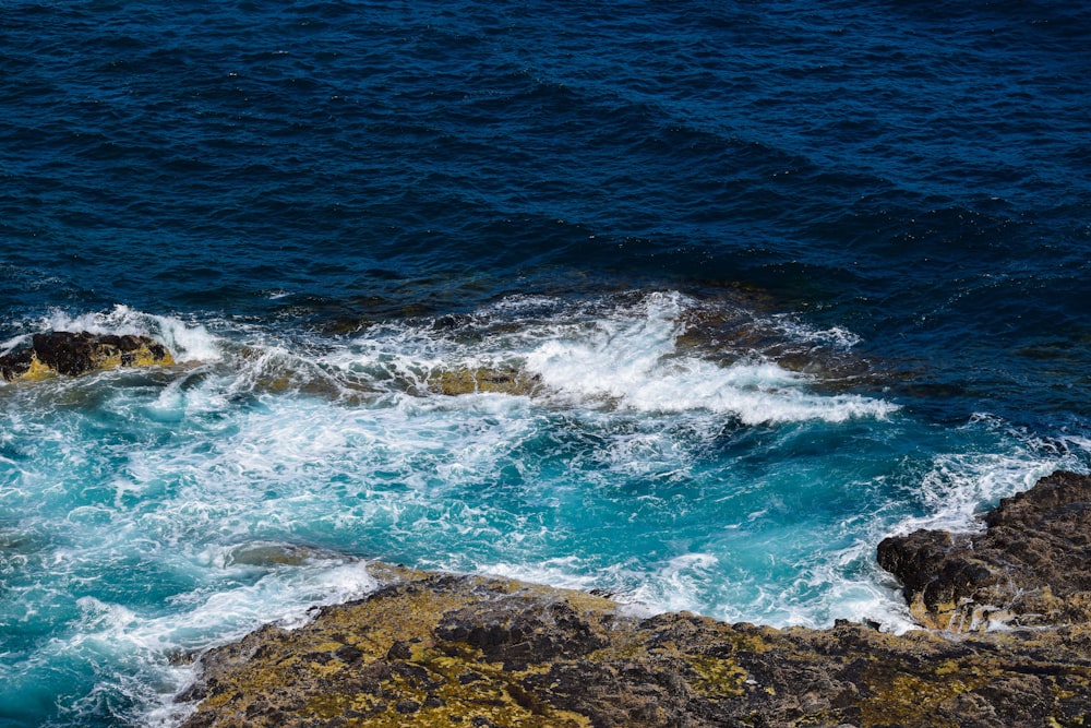 a couple of rocks sitting on top of a body of water