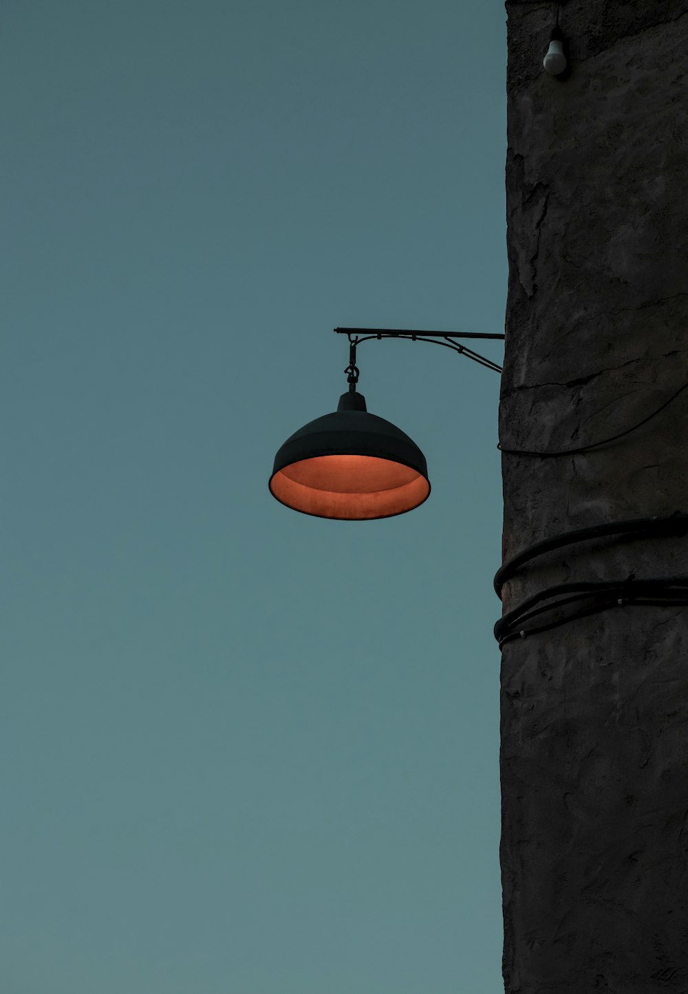 an orange light hanging from the side of a building