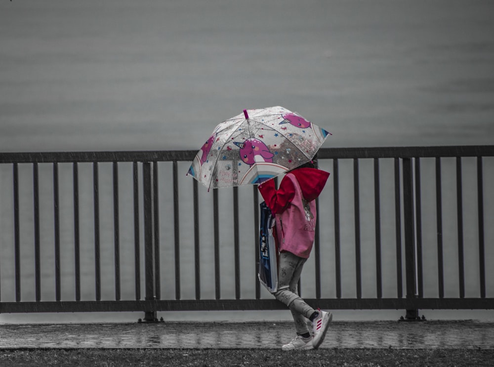 a woman walking down a street holding an umbrella