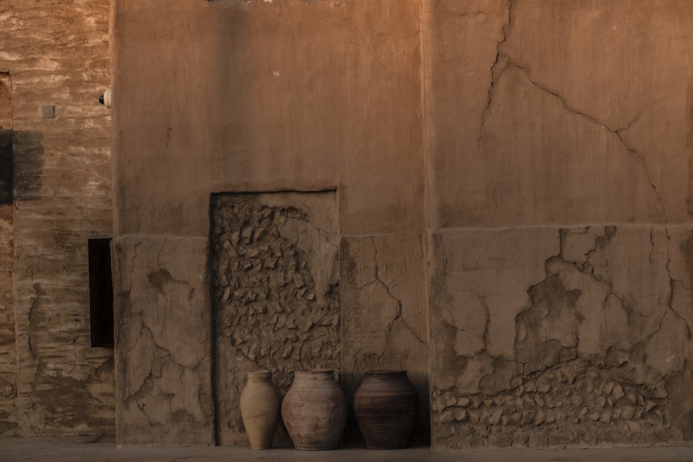 a couple of vases sitting next to a wall