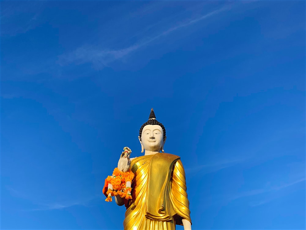 a golden buddha statue with a blue sky in the background