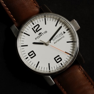 a close up of a watch on a black surface