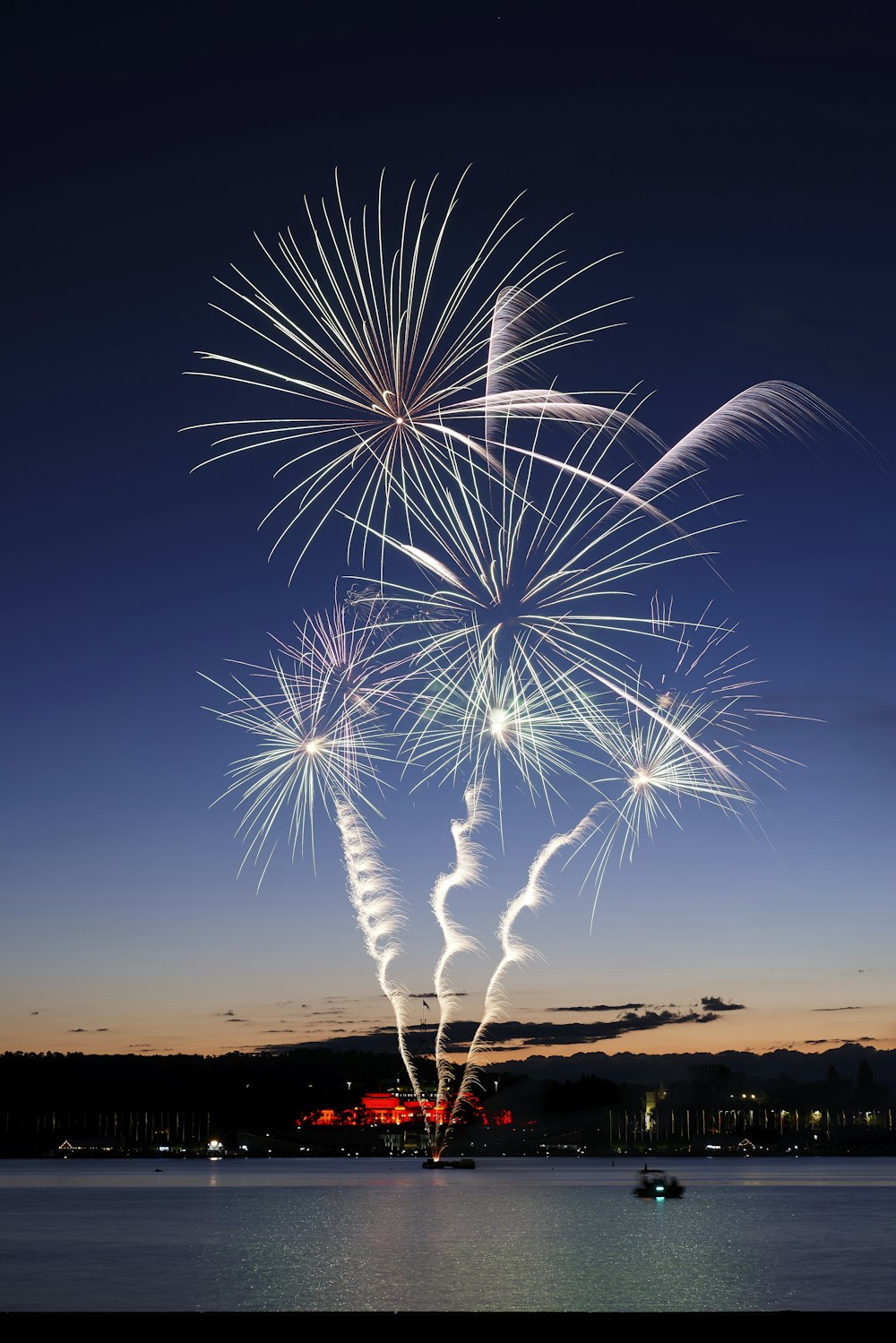 a fireworks display in the sky over a body of water