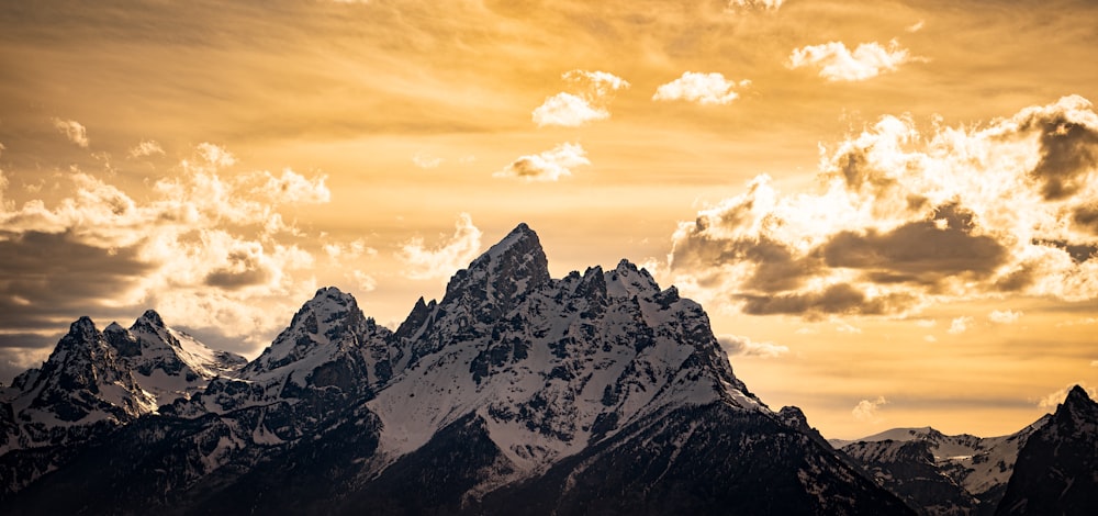 a mountain range with clouds in the sky