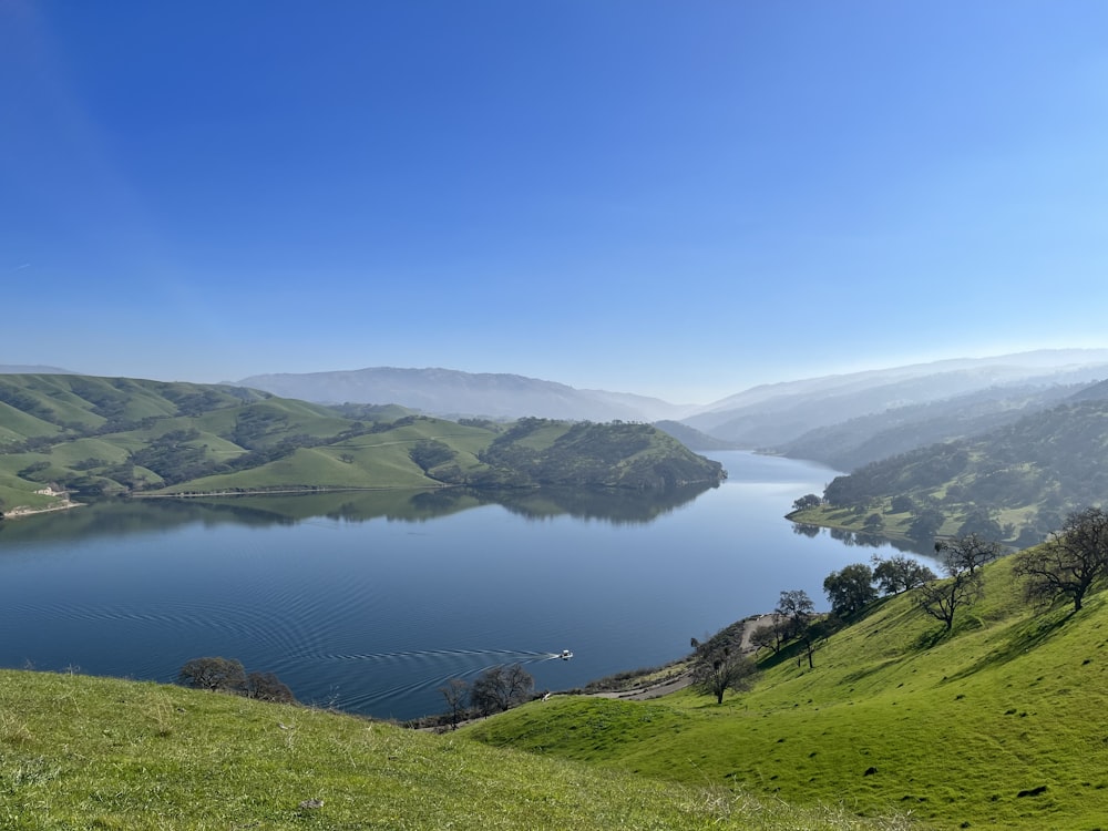 a large body of water surrounded by lush green hills