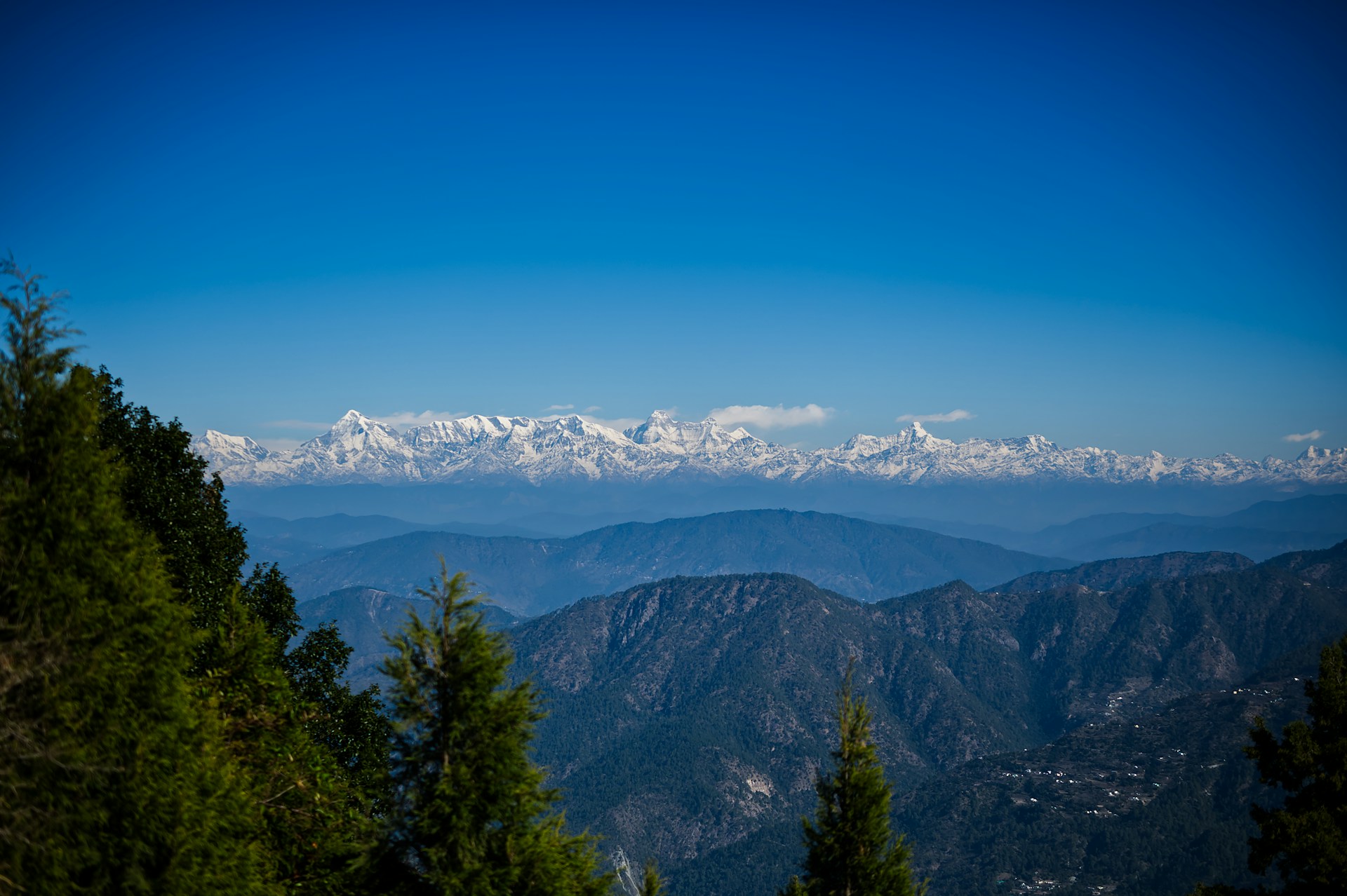 a view of a mountain range with snow capped mountains in the distance