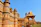 Historic Omani fort with intricate stonework and visitors admiring the architecture on a clear day.