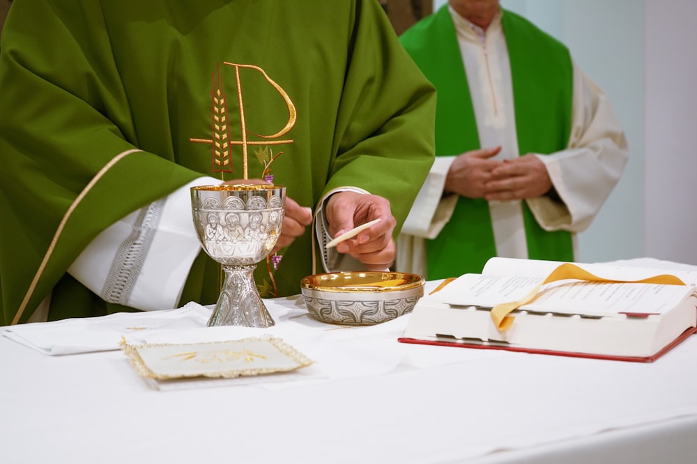 Un sacerdote está encendiendo una vela sobre una mesa