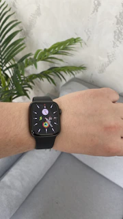 A cozy living room with a senior using a smartwatch and a medical alert device on the table.