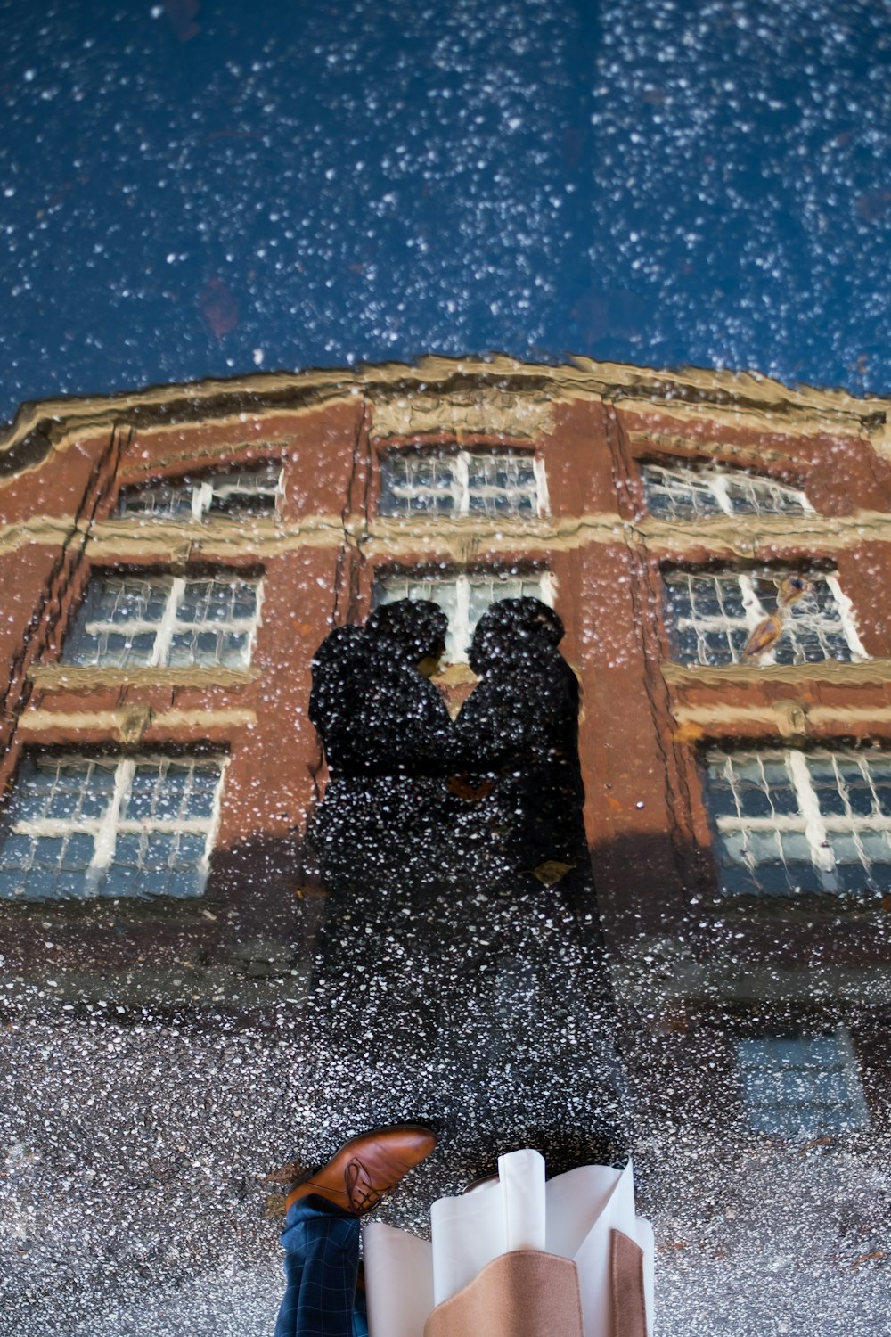 a reflection of two people standing in front of a building