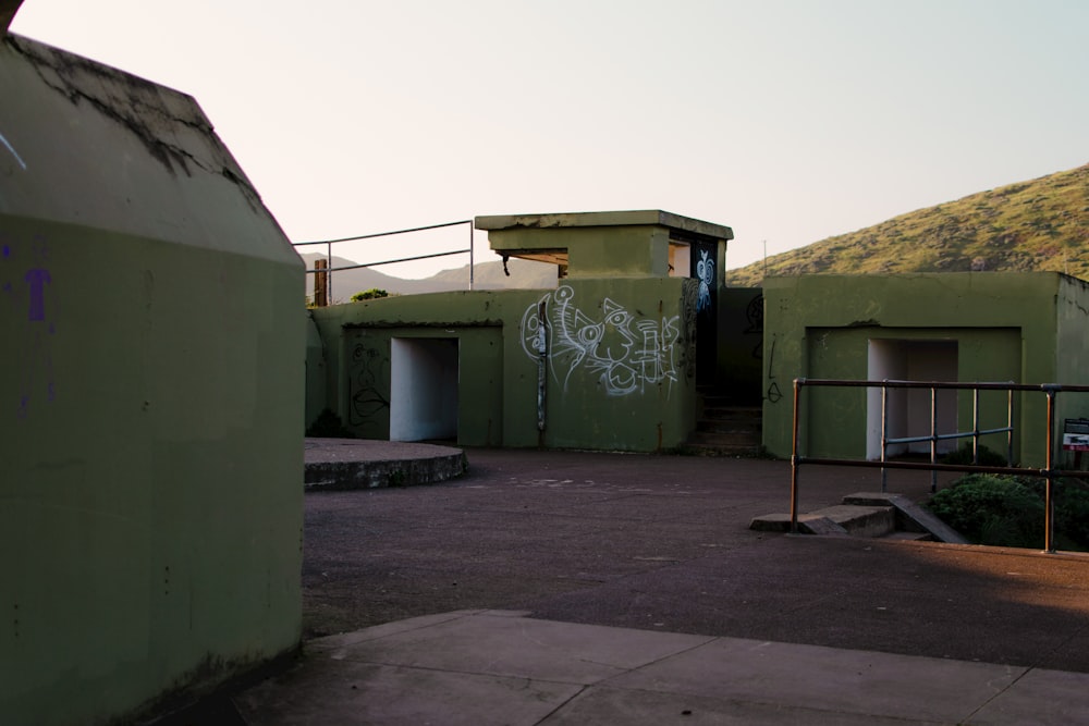 um edifício verde com grafite ao lado dele