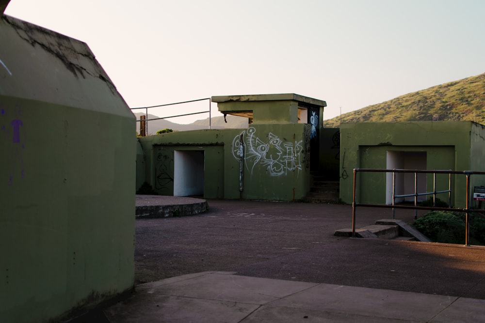 a green building with graffiti on the side of it