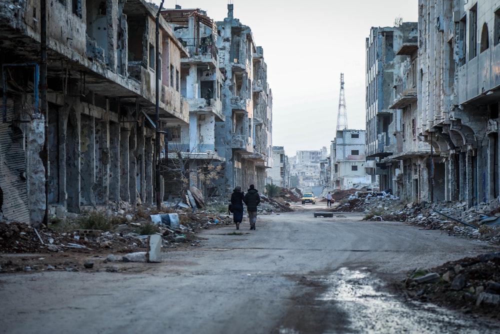 a couple of people walking down a dirty street