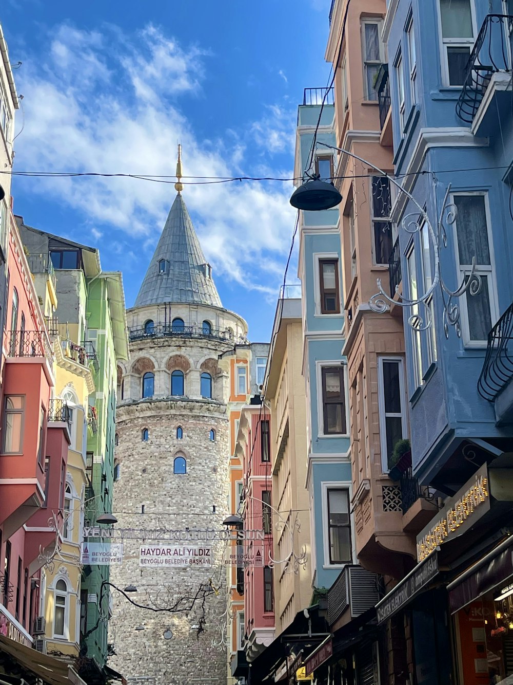 a narrow city street with a tower in the background