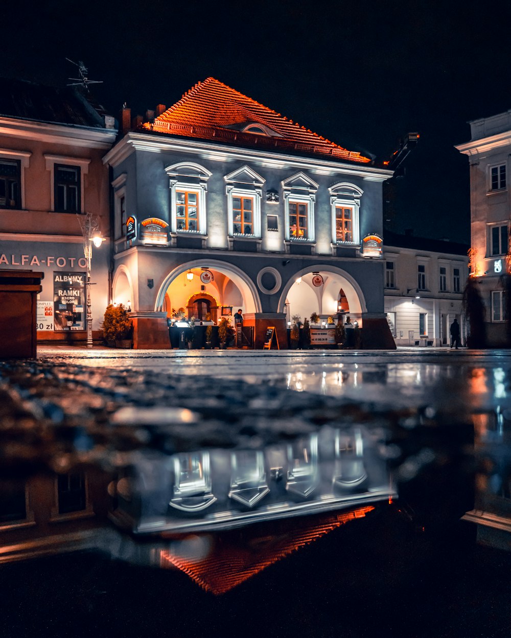 a reflection of a building in a puddle of water