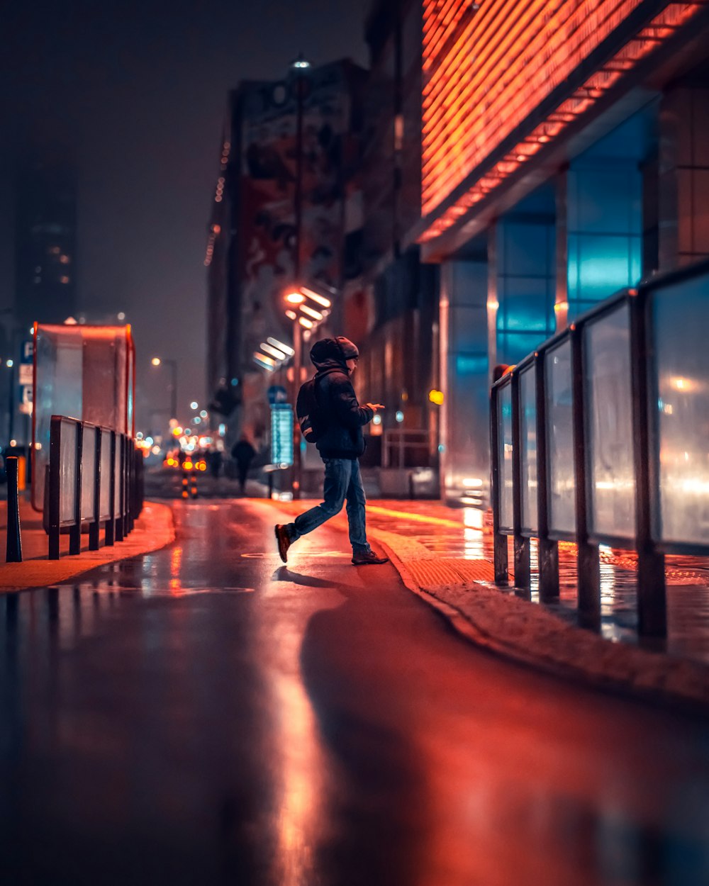 a person walking down a street at night