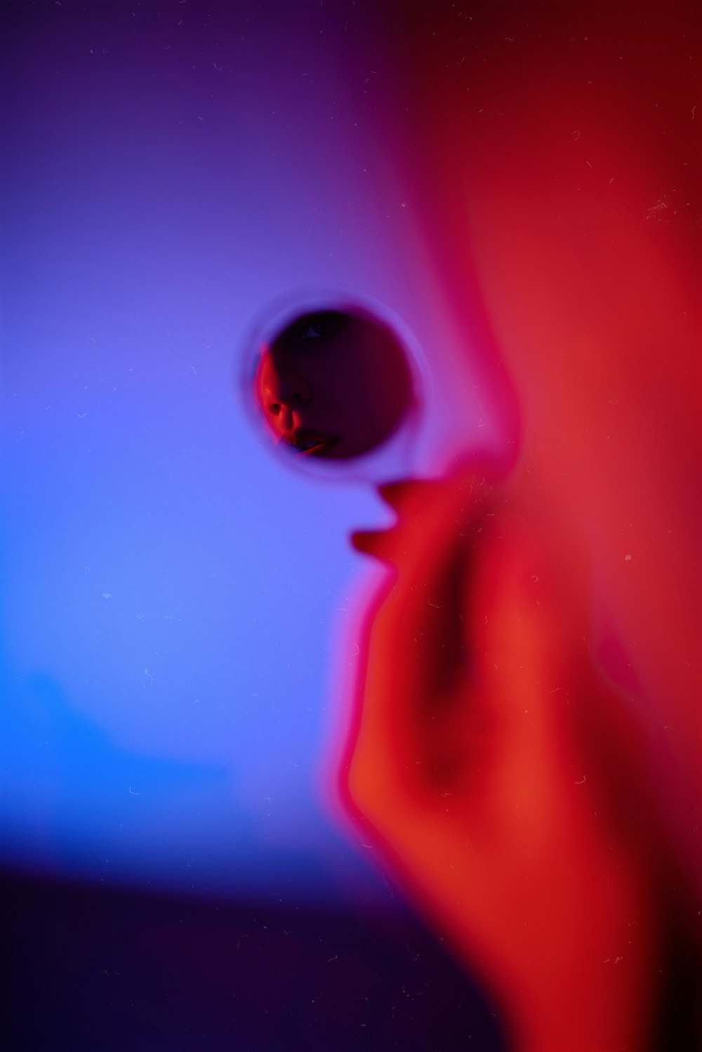 a blurry image of a person's face with a red and blue background
