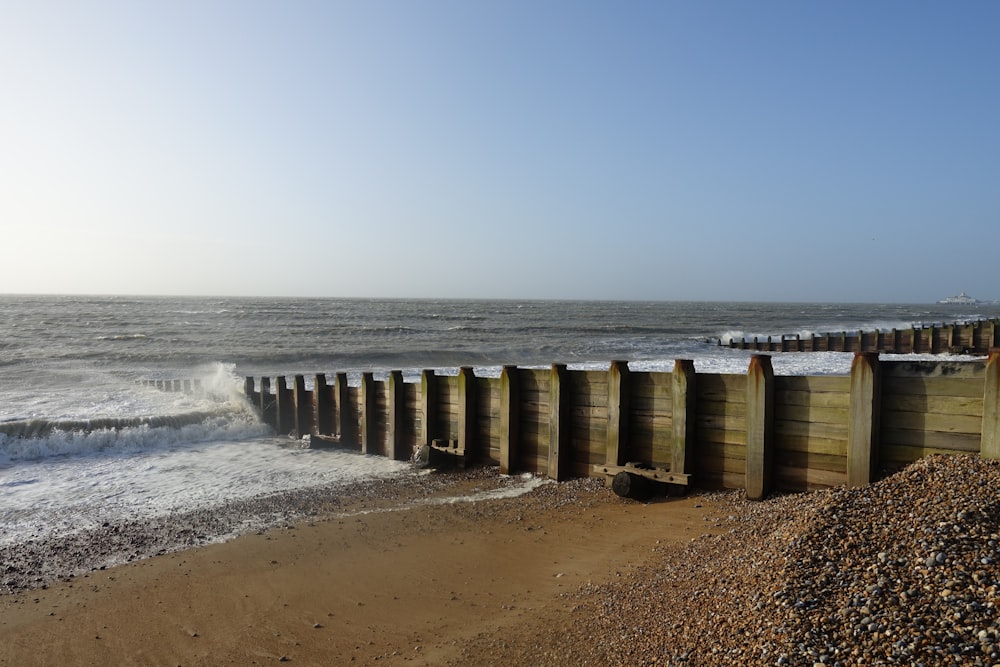 a row of wooden posts sitting on top of a beach