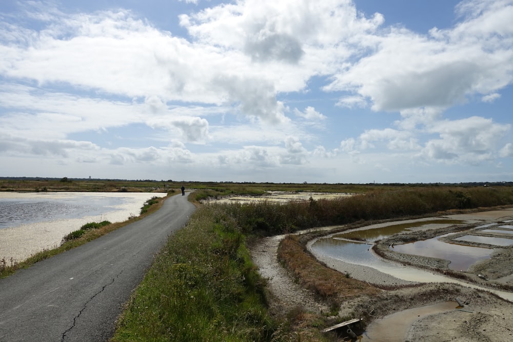 a dirt road next to a body of water