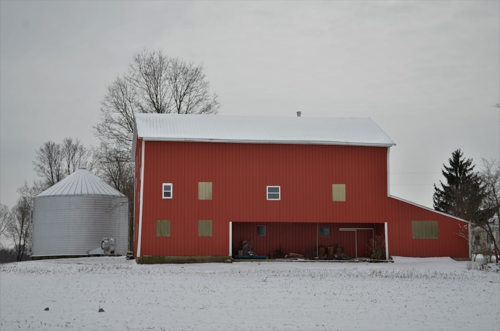 a red barn with two silos in the background