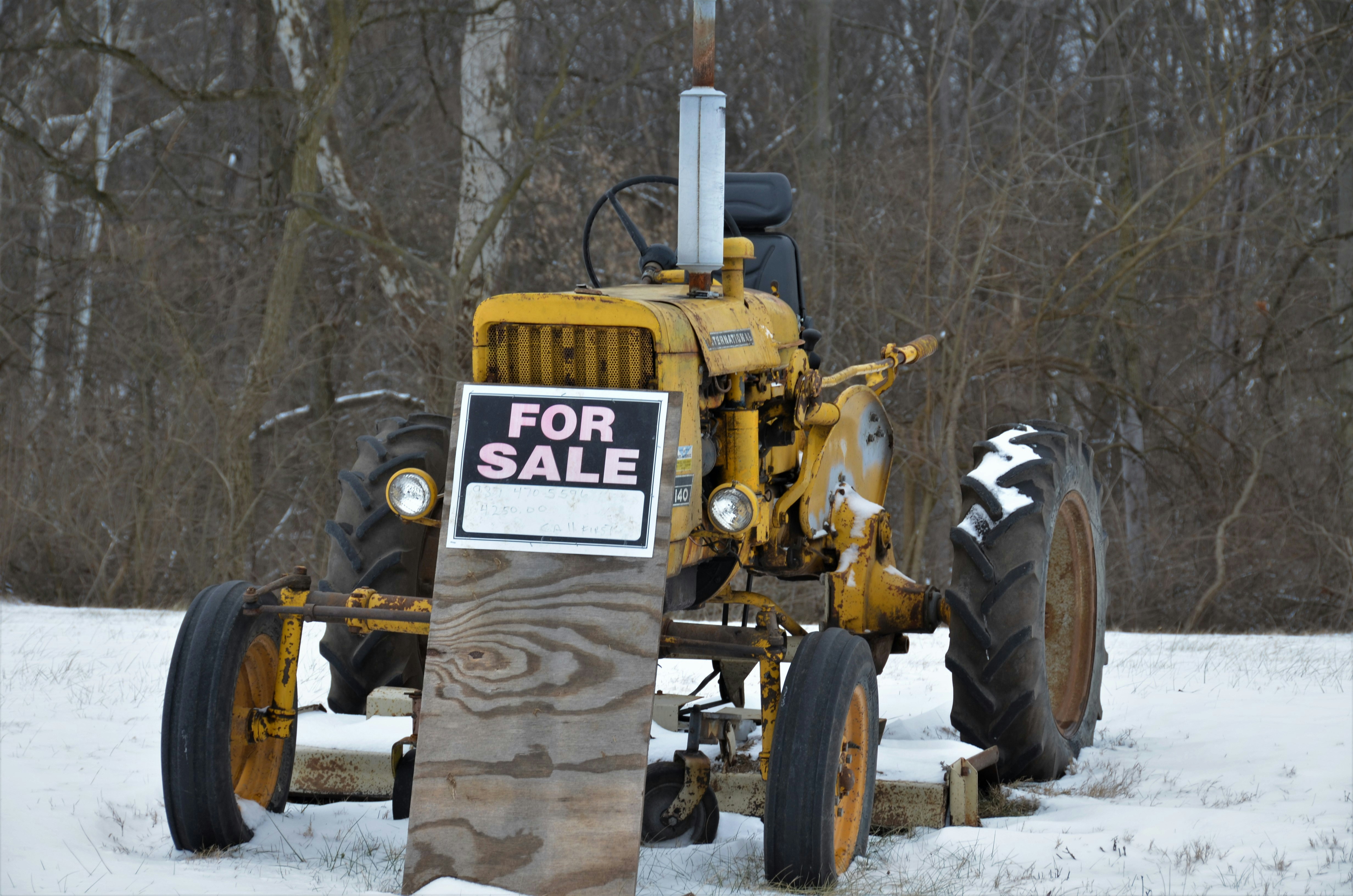 Small yellow International tractor with belly mount mower