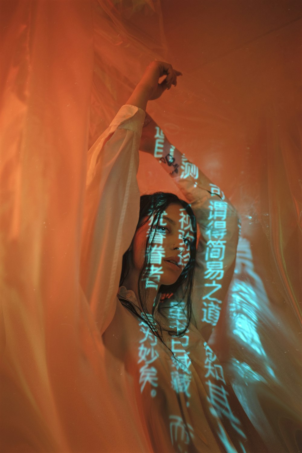 a woman with long hair standing in front of a curtain