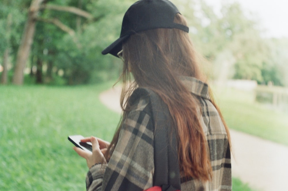 a woman with long hair is looking at her cell phone