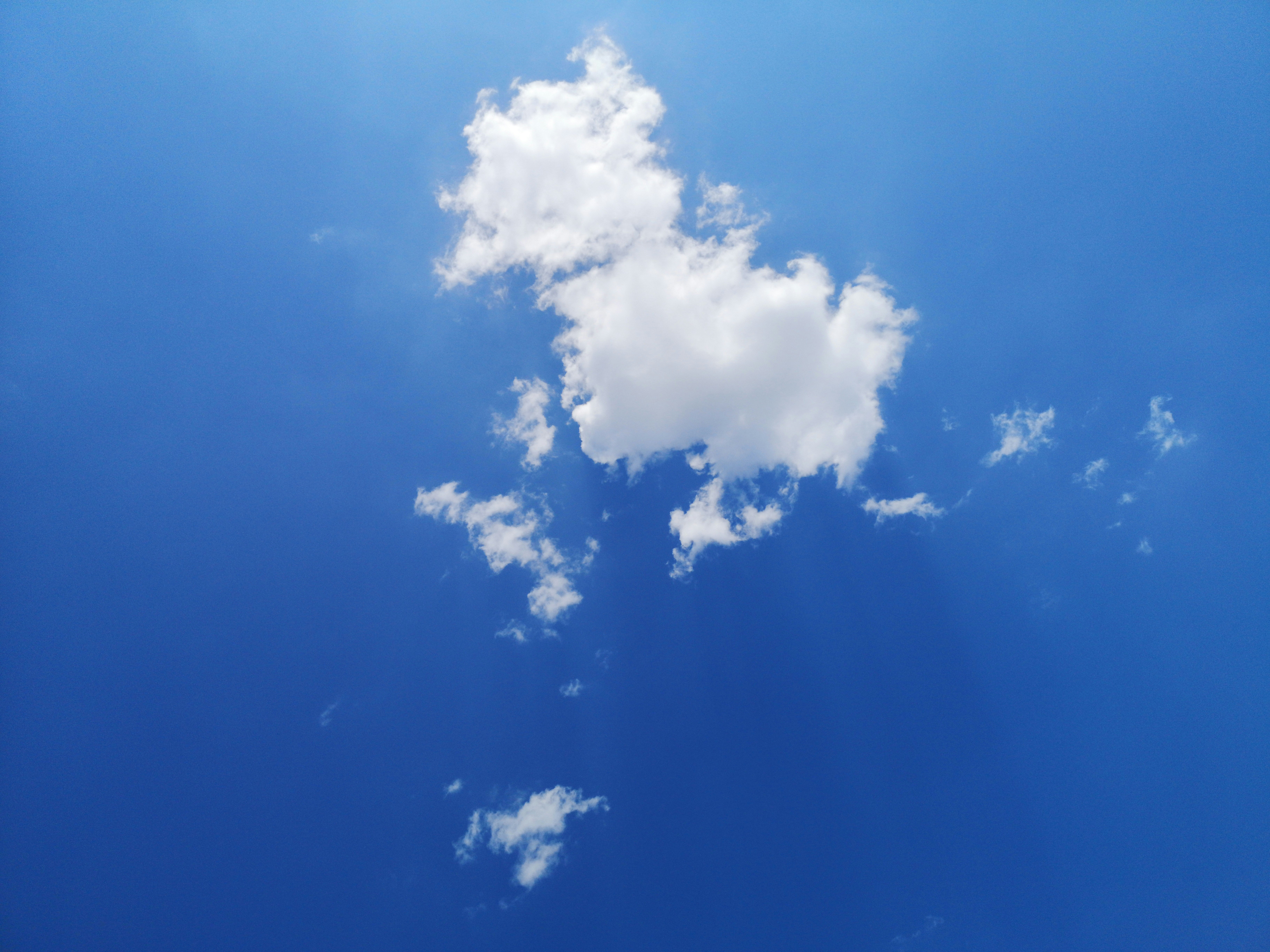 A plane flying through a blue sky with clouds photo – Free Nature Image ...