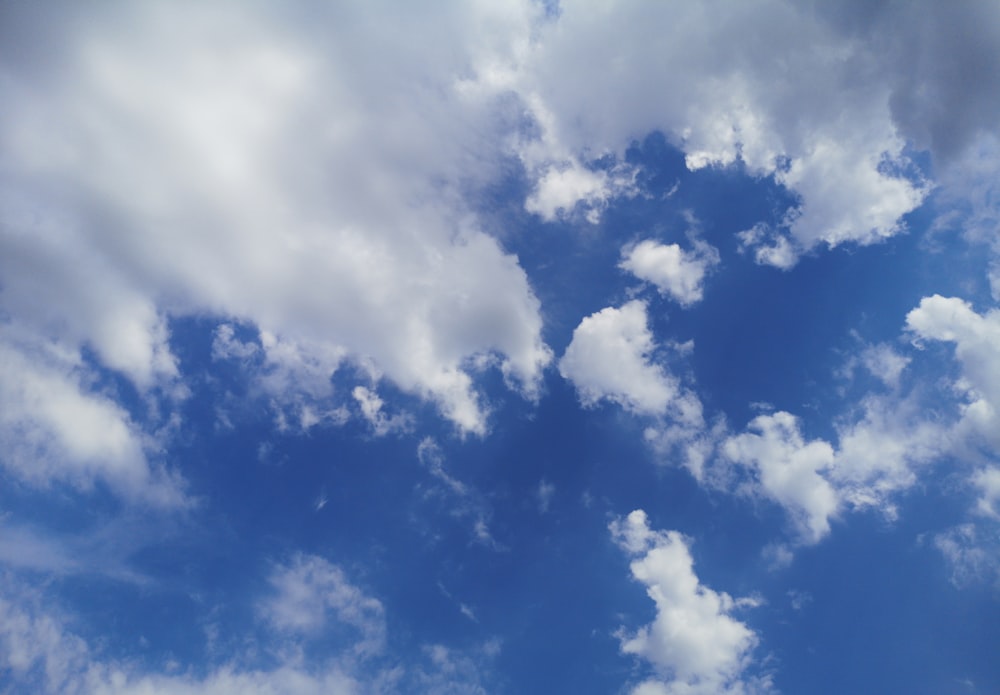 a plane is flying through the blue sky