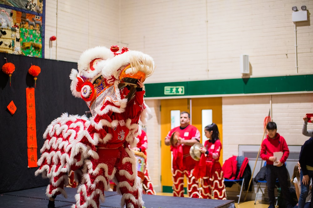 a man in a red and white lion costume