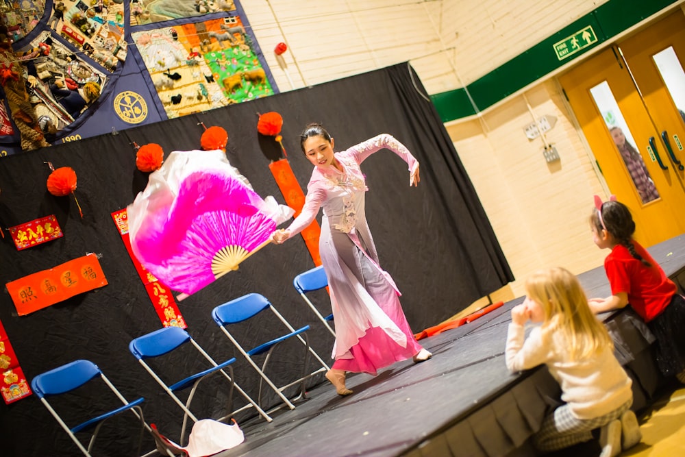 a young girl is performing a chinese dance