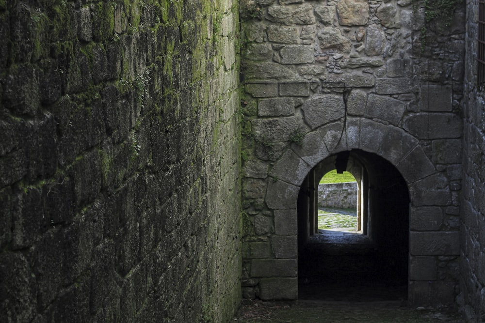 a stone tunnel with a light at the end