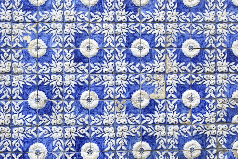 a blue and white tile with white flowers on it
