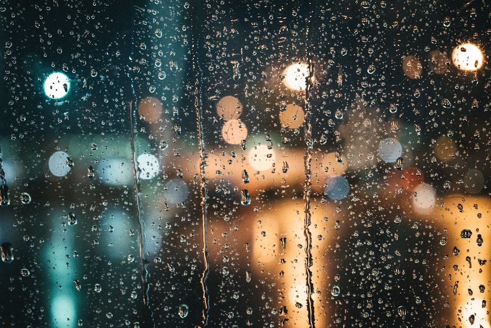 une fenêtre avec des gouttes de pluie dessus la nuit