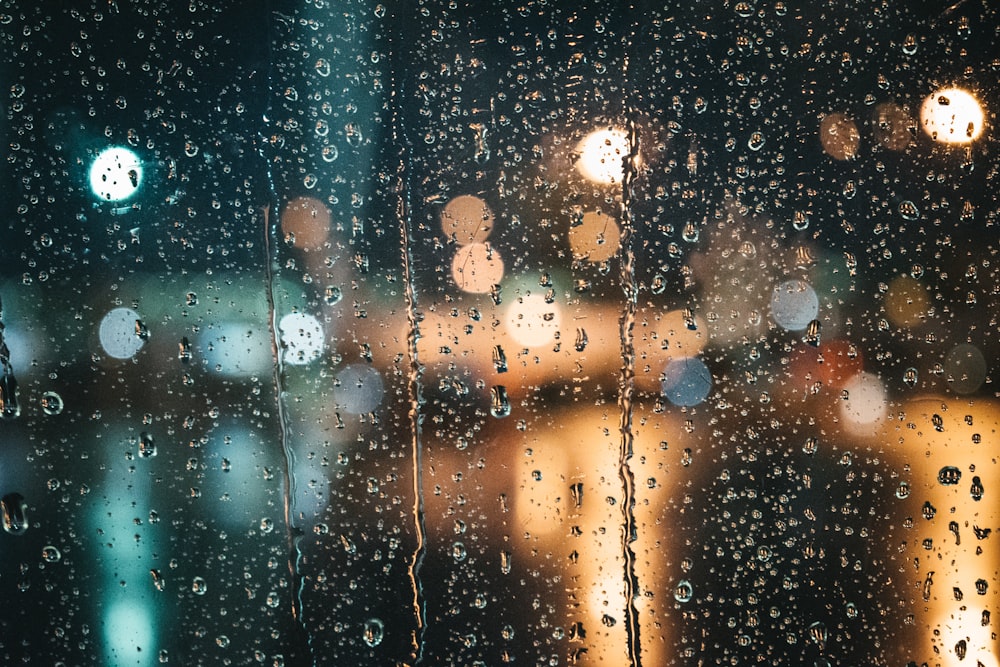 a window with rain drops on it at night