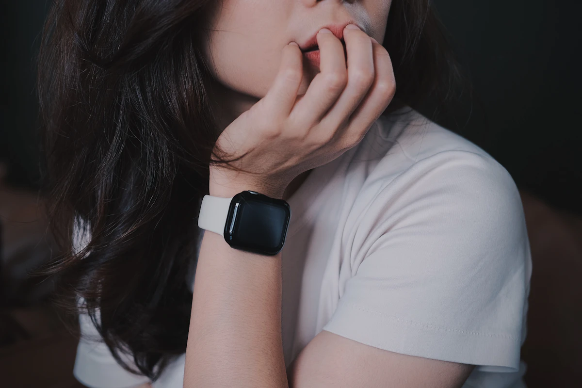 Woman resting her chin on her hand while wearing an Apple Watch