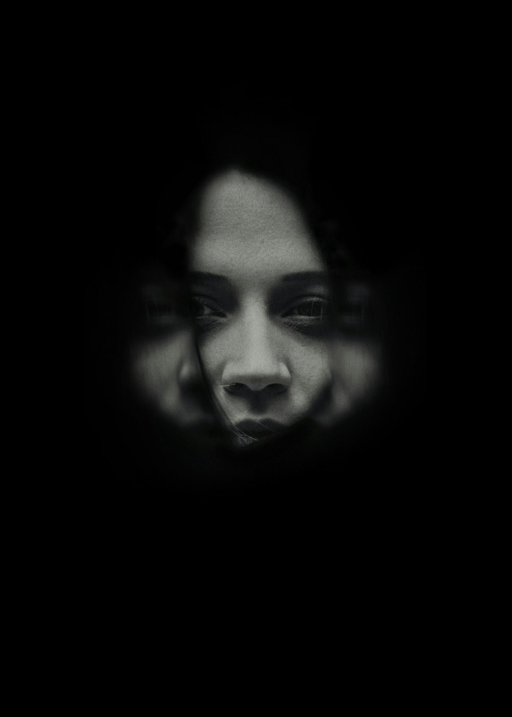 a woman's face is seen through a dark background