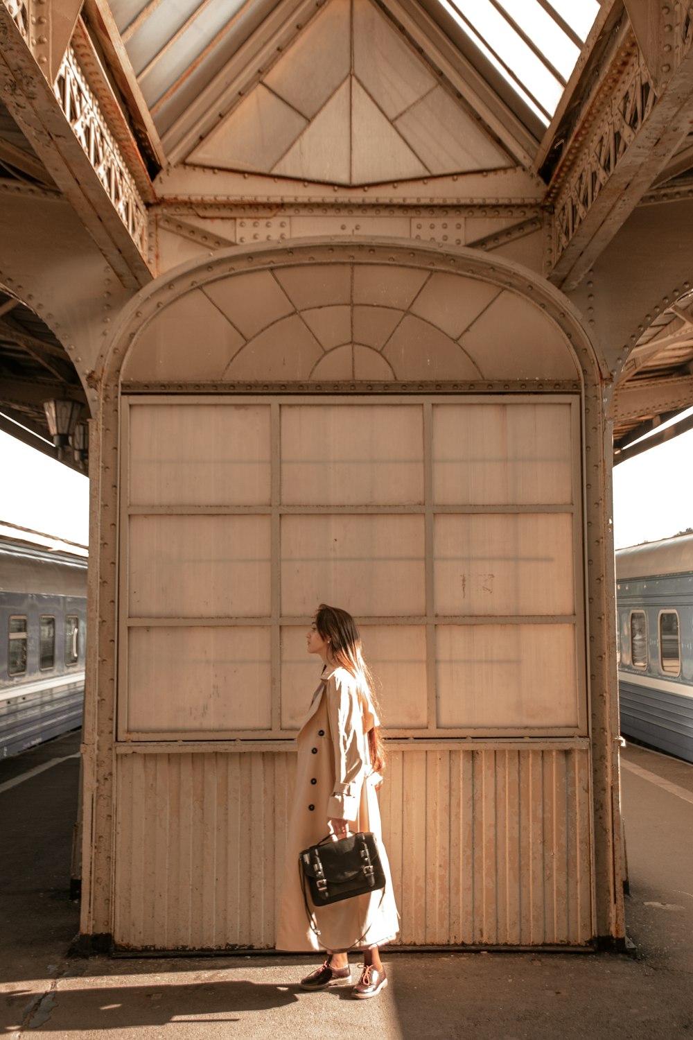 a woman standing in a train station with a suitcase