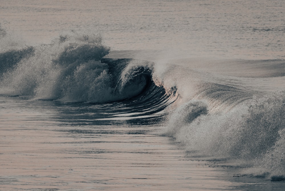 a large wave crashes into the shore of the ocean